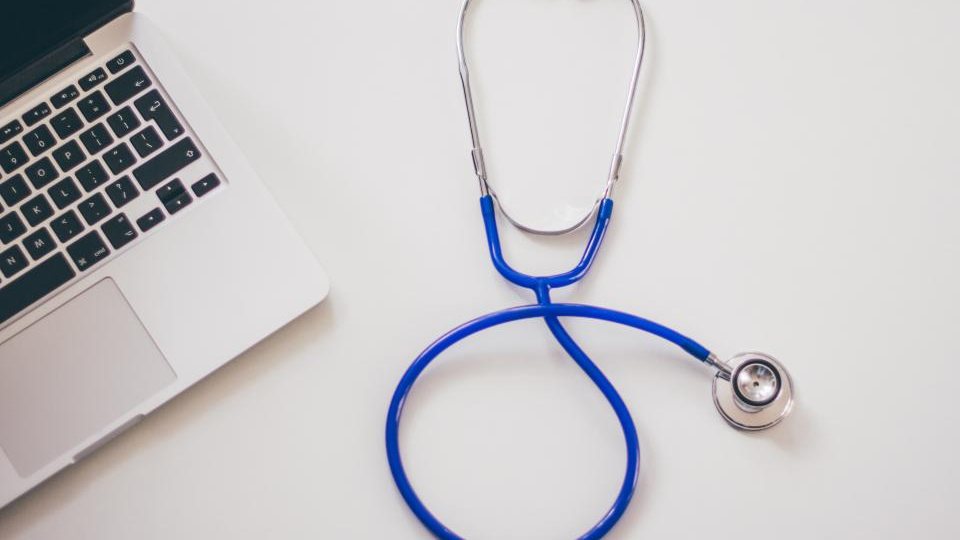 Stetoskop vedľa notebooku na bielom stole, web pre lekára a ambulanciu